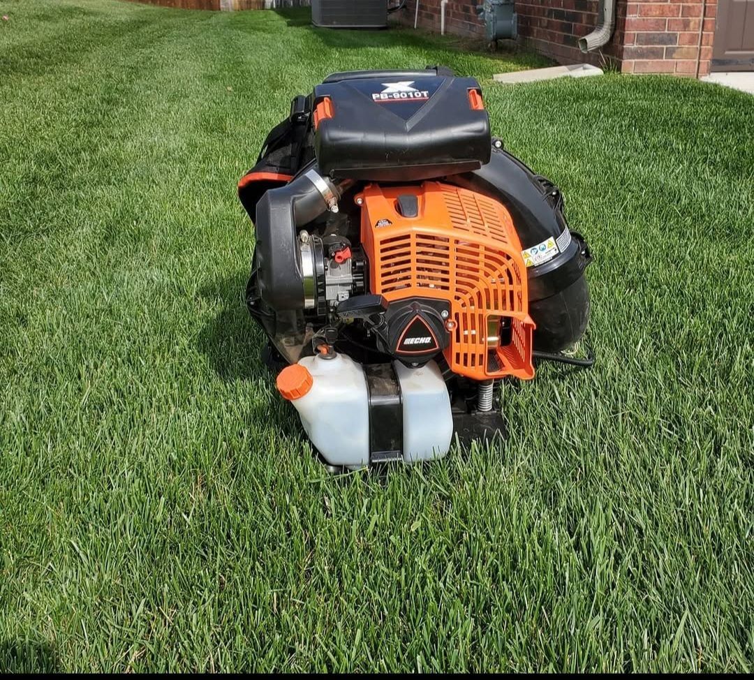 A lawn mower is sitting on top of a lush green lawn