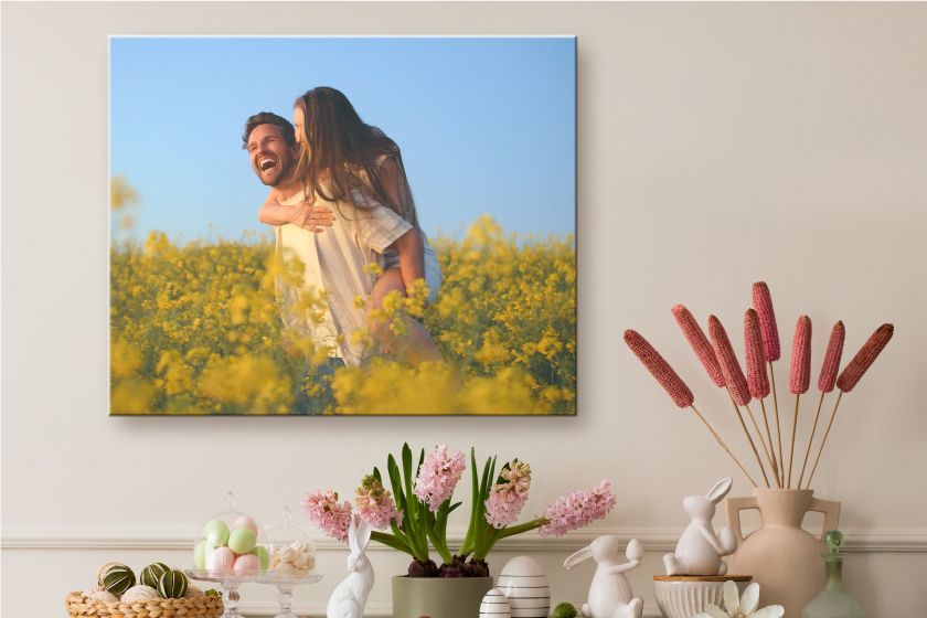 Canvas print on a wall with two people walking on the beach at sunset