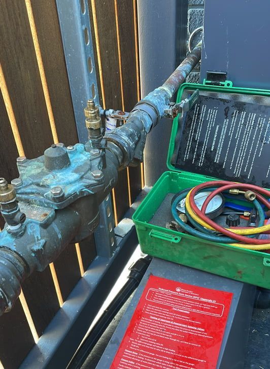 A Green Box With A Hose Attached To It — Russell Plumbing In Manunda, QLD
