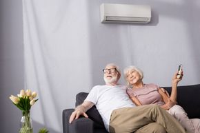 couple sitting under air conditioner