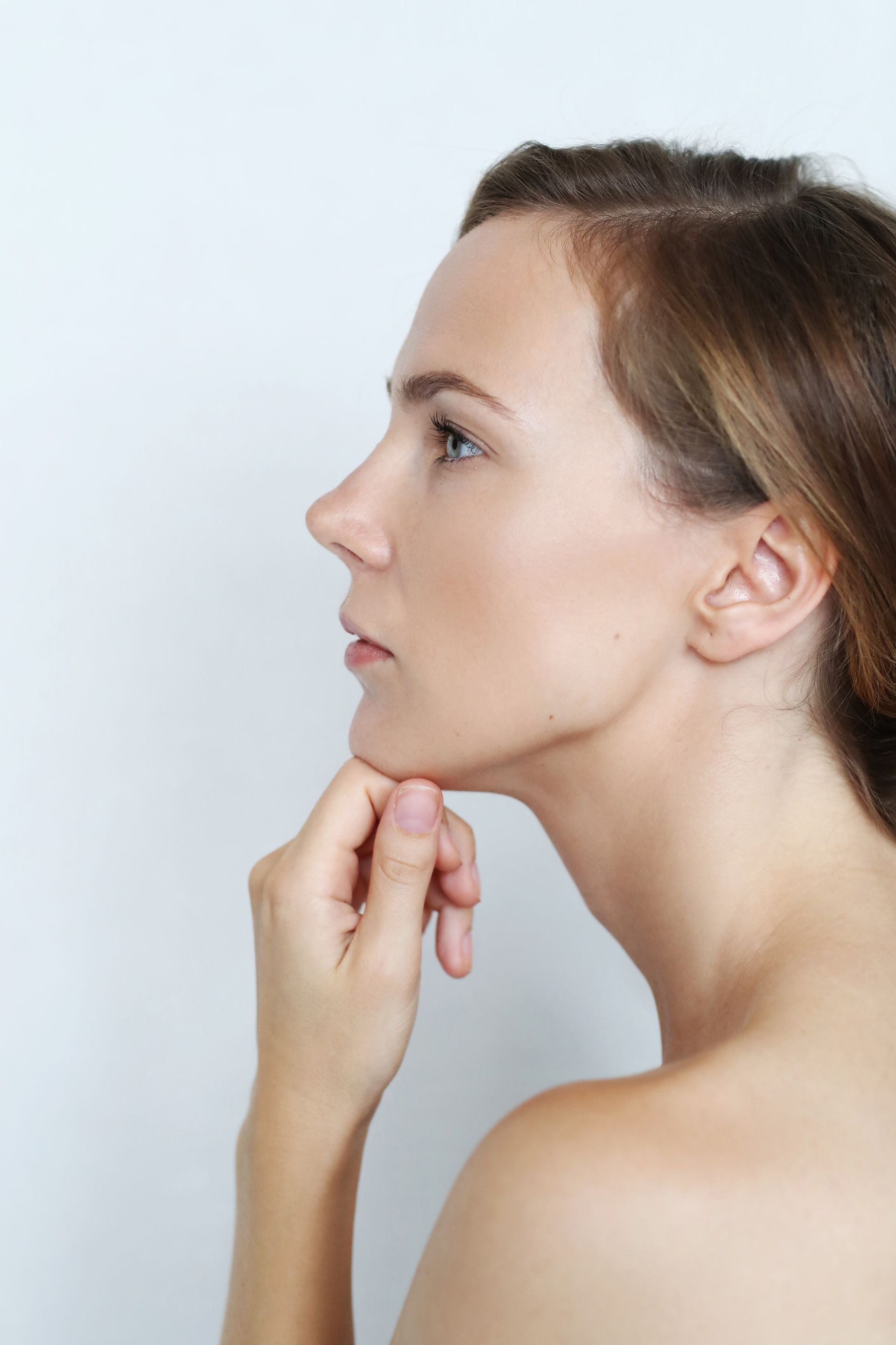 A woman is touching her chin with her hand.