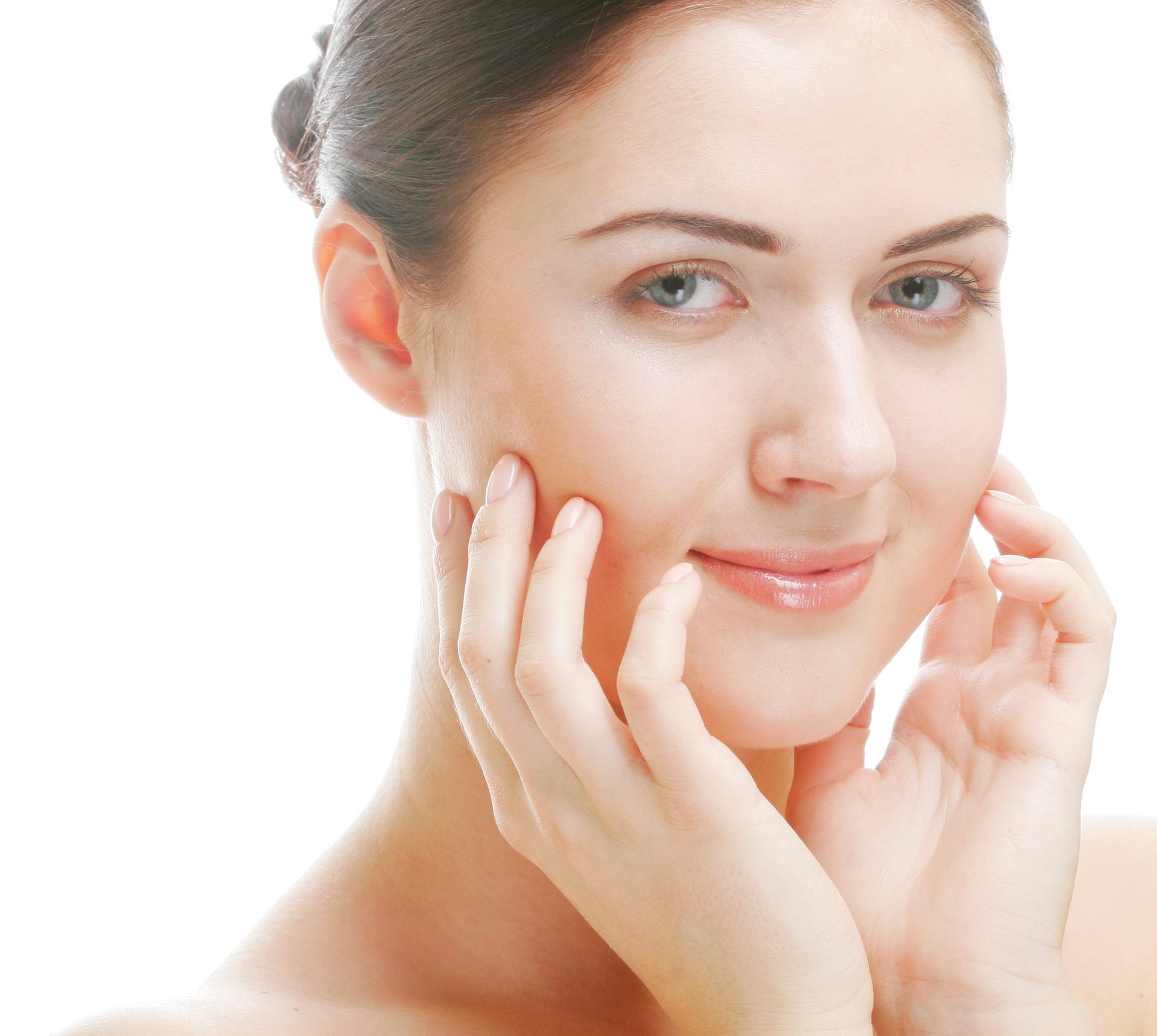 A woman is touching her face with her hands and smiling