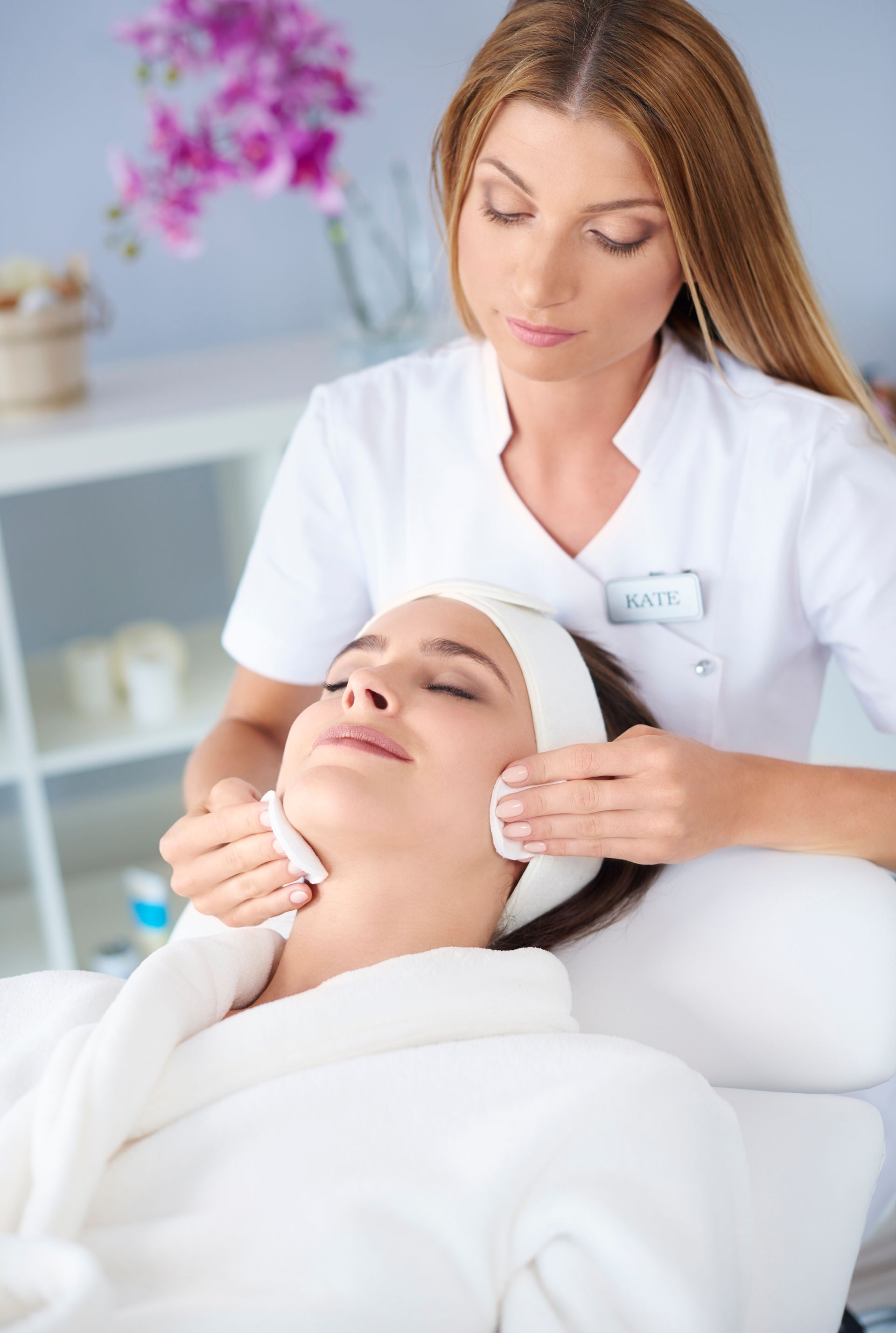 A woman is getting a facial treatment at a beauty salon.