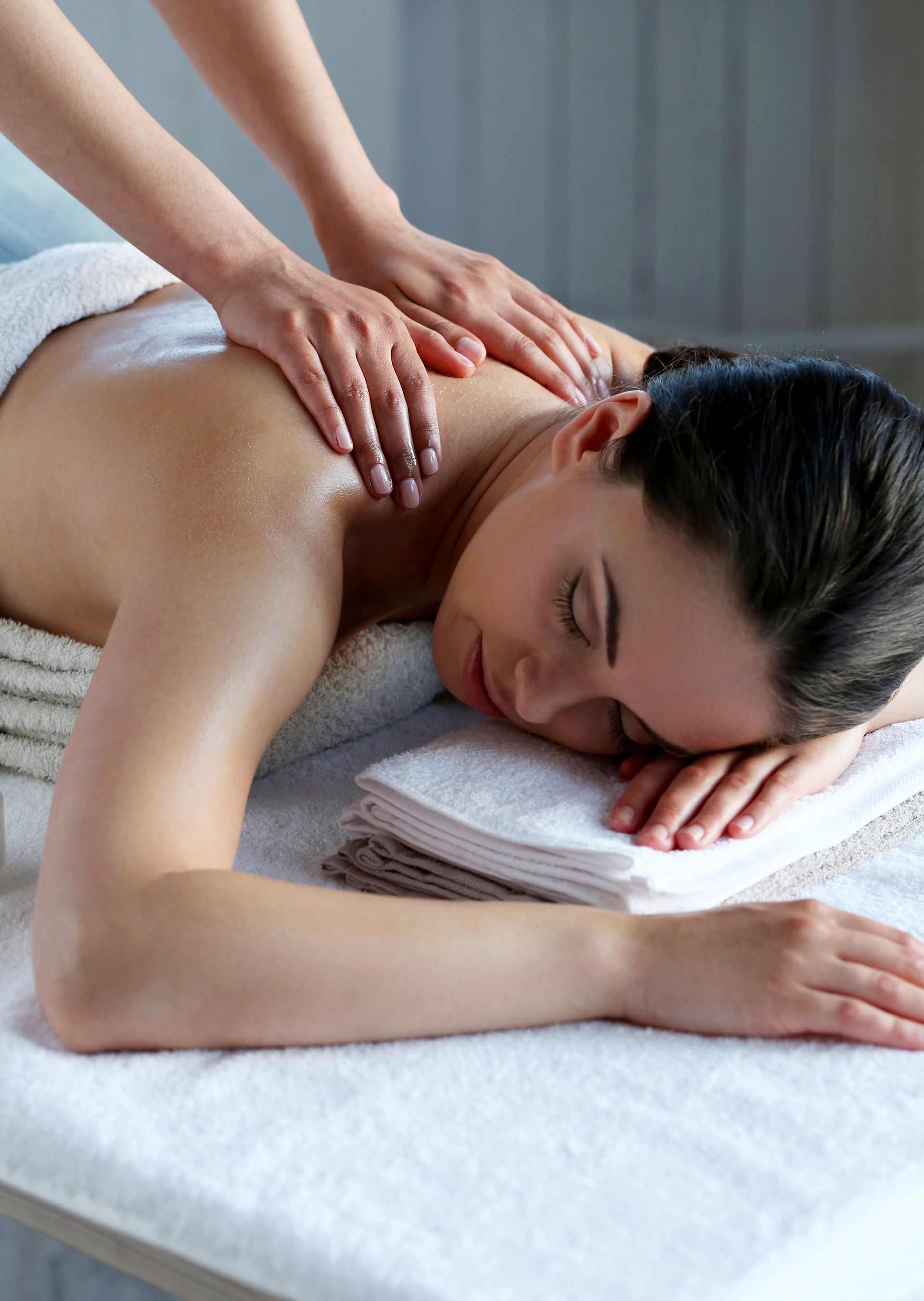 A woman is laying on a table getting a massage.