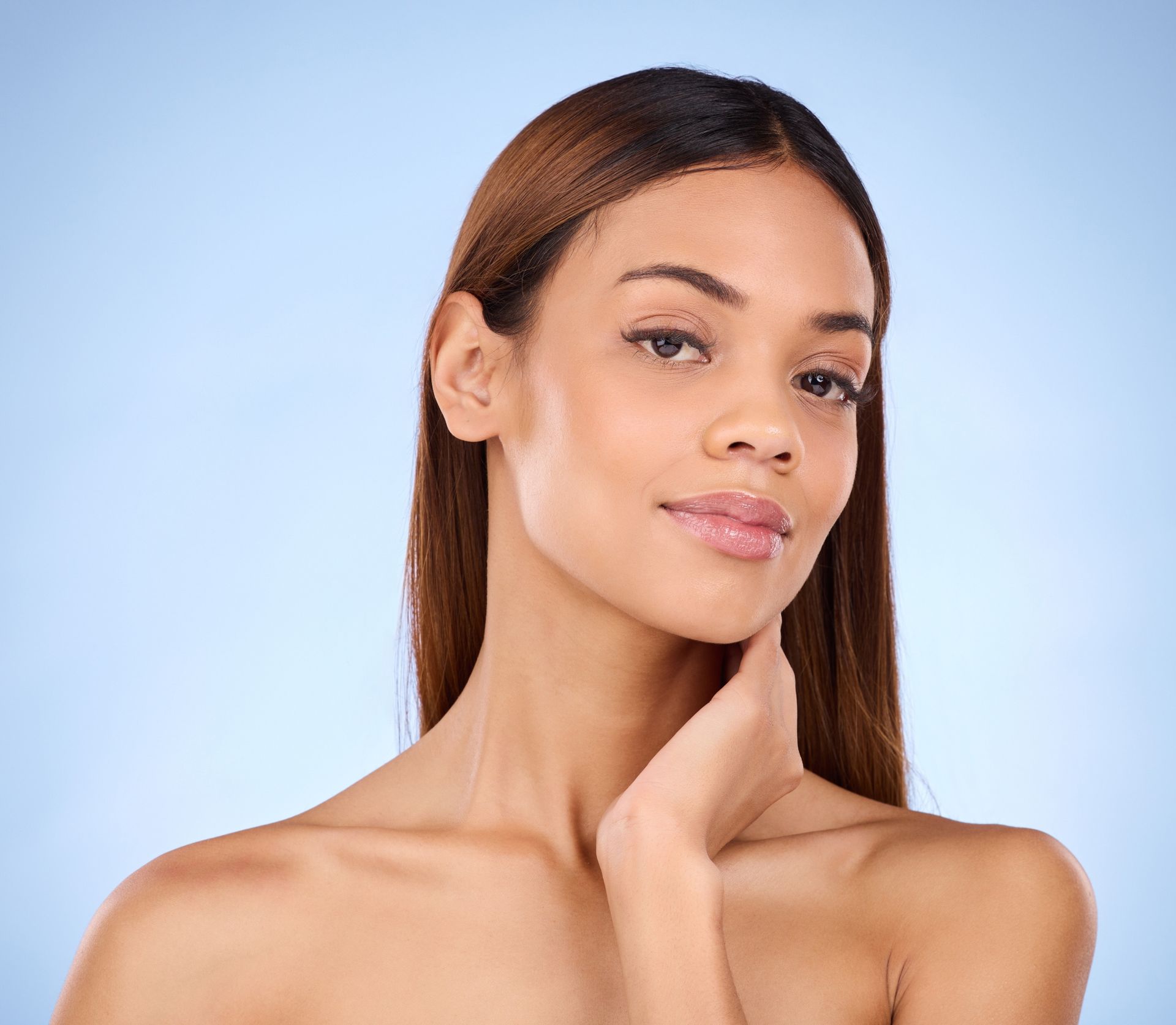 A close up of a woman 's face with her hand on her chin.