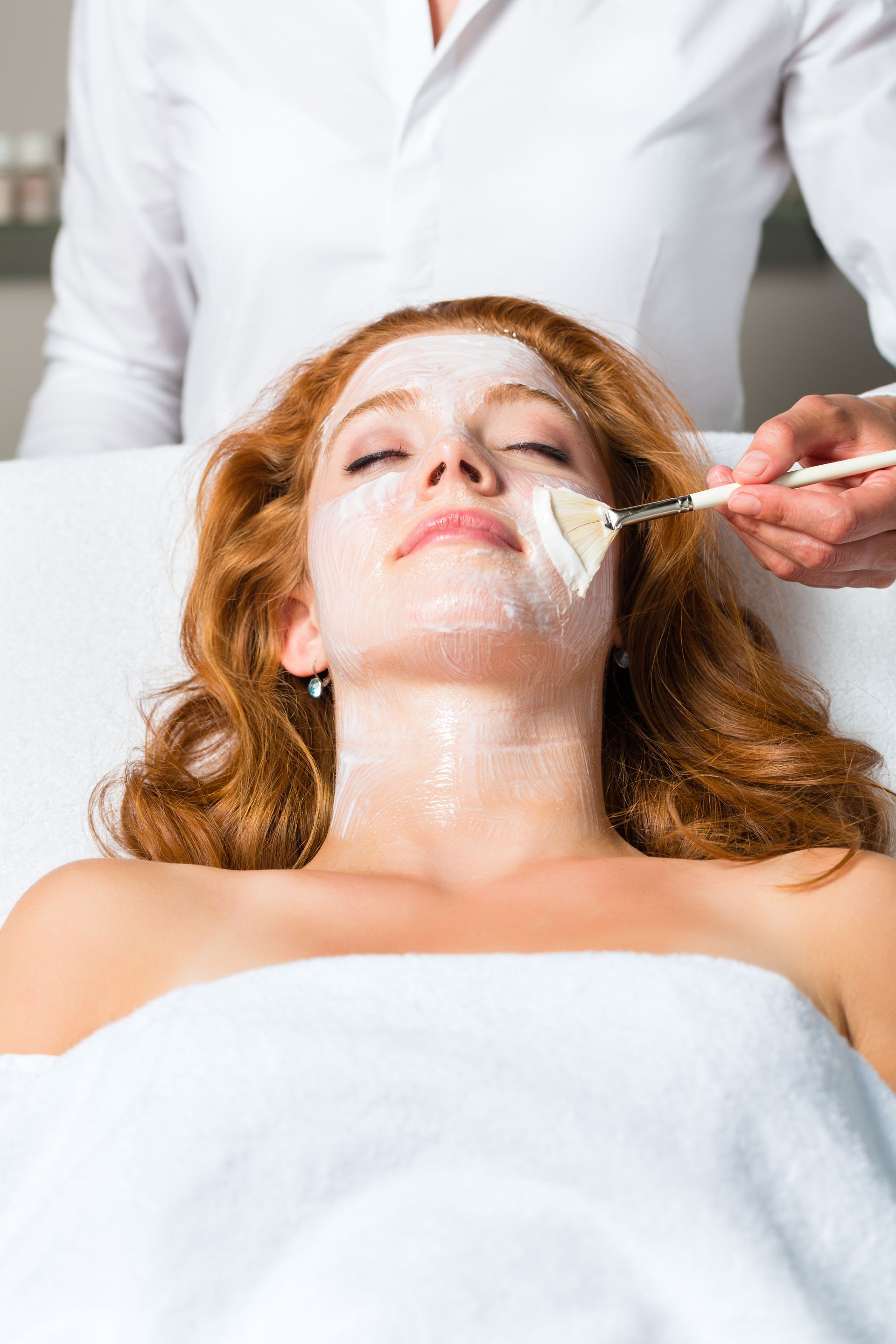 A woman is getting a facial treatment at a spa.