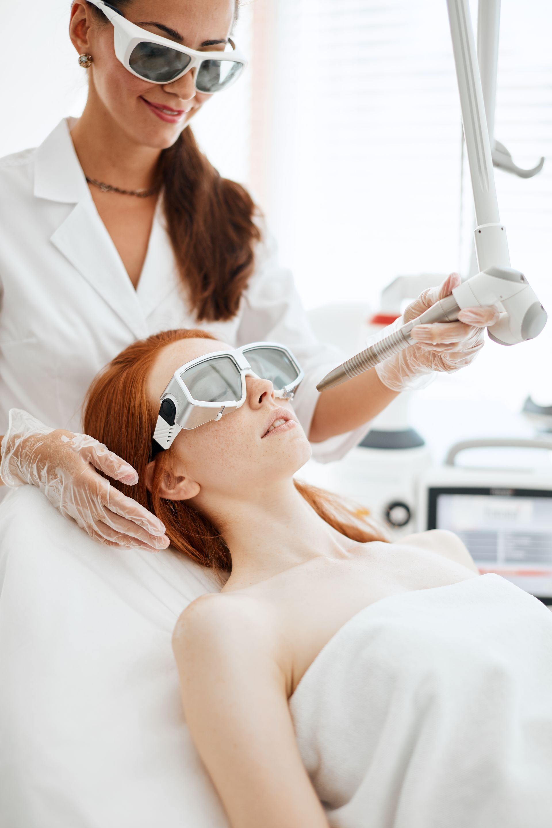 A woman is getting a laser treatment on her face.