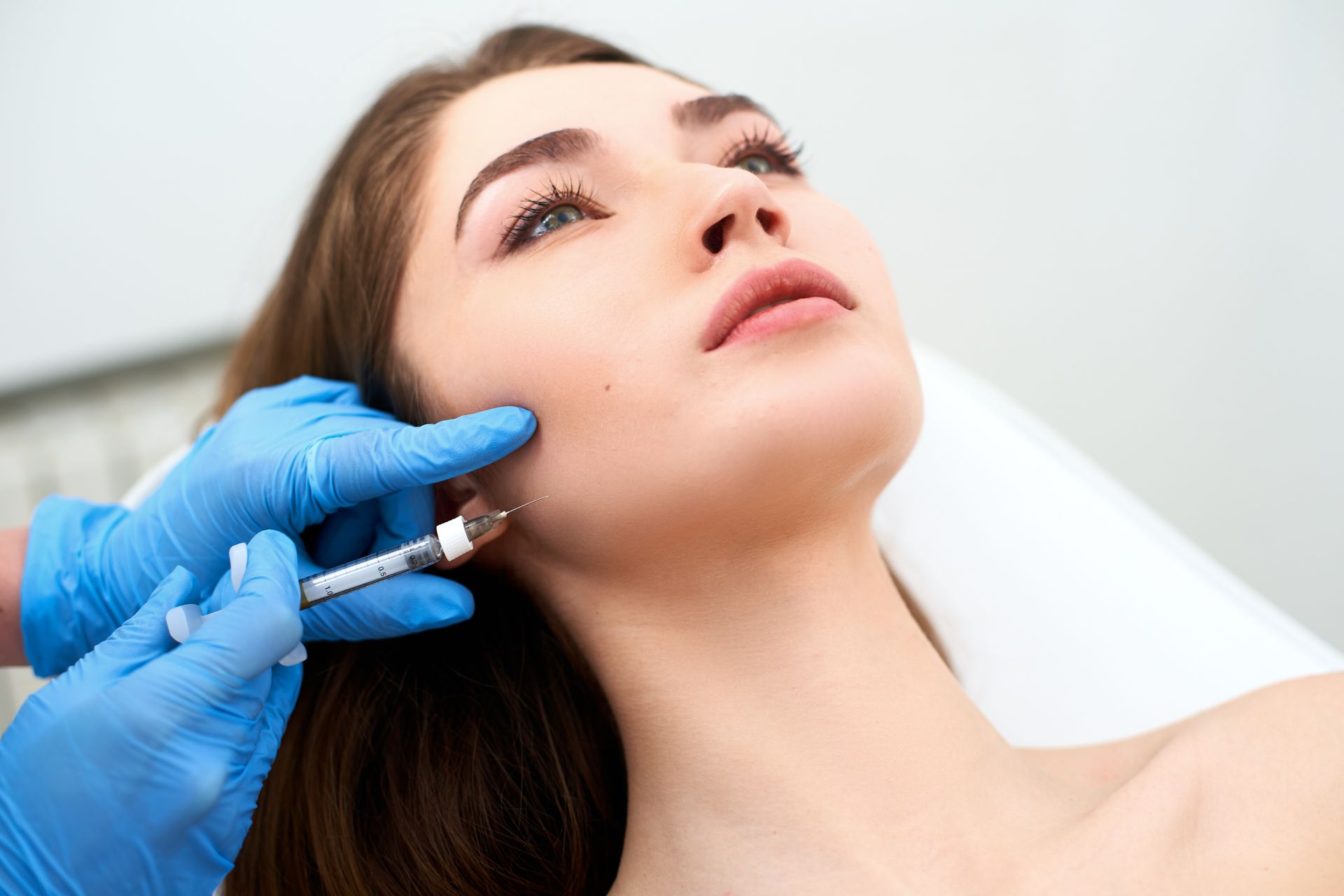 A woman is getting a botox injection in her face.