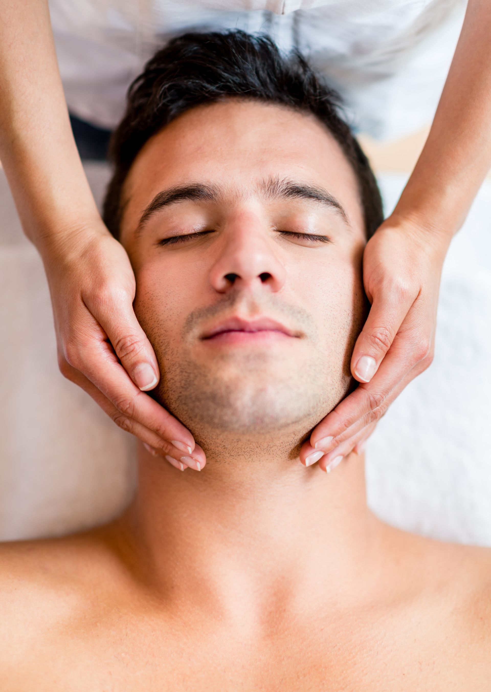 A man is getting a face massage at a spa.