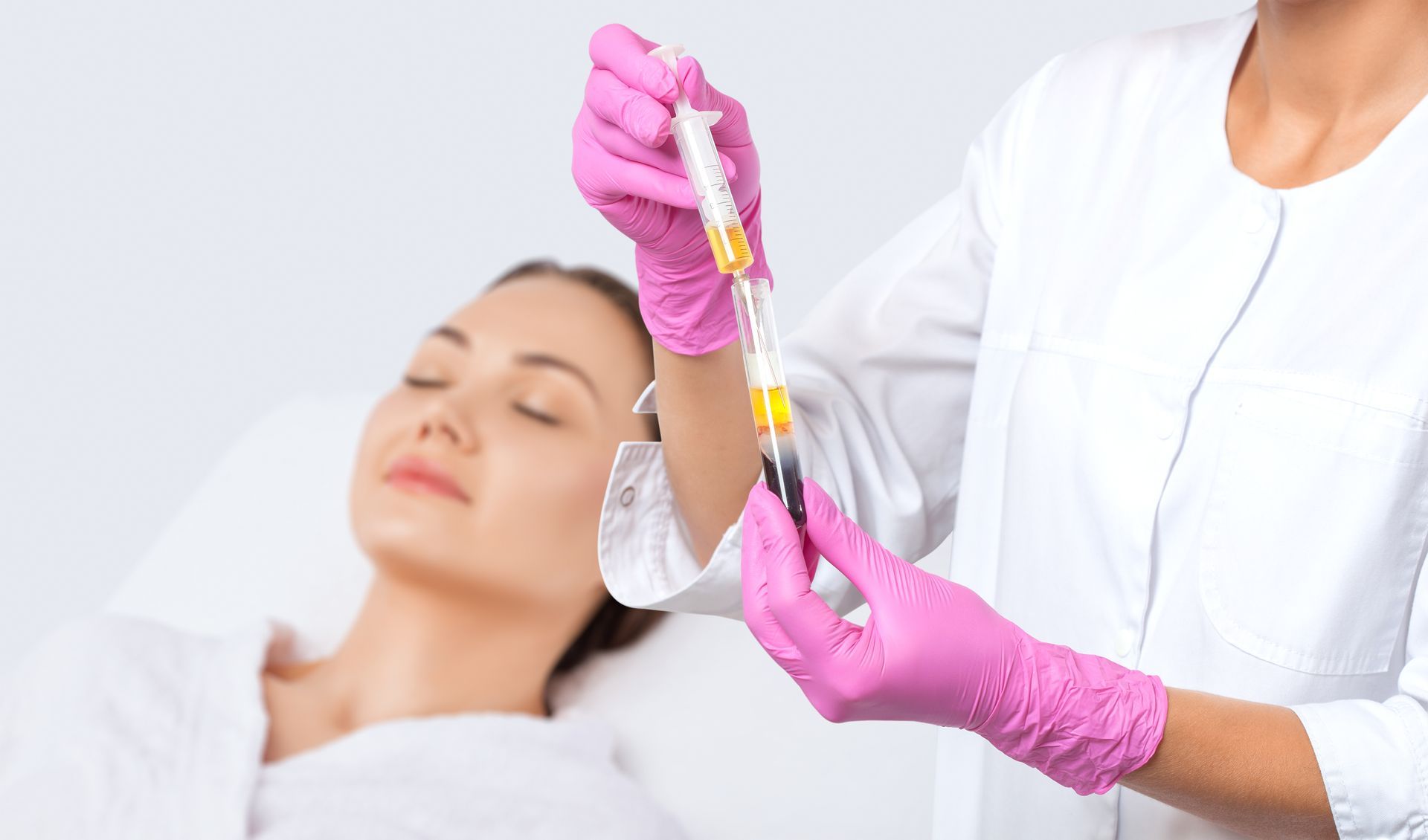 A doctor is holding a syringe in front of a patient.