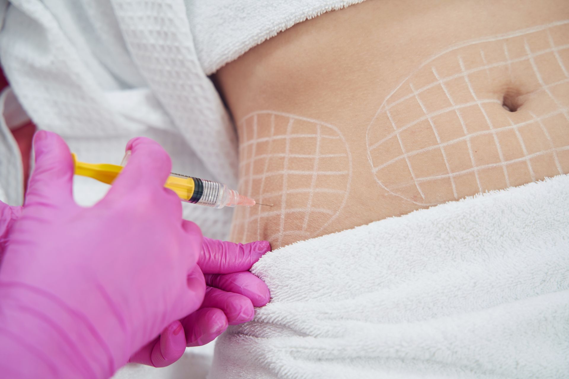 A woman is getting an injection in her stomach.