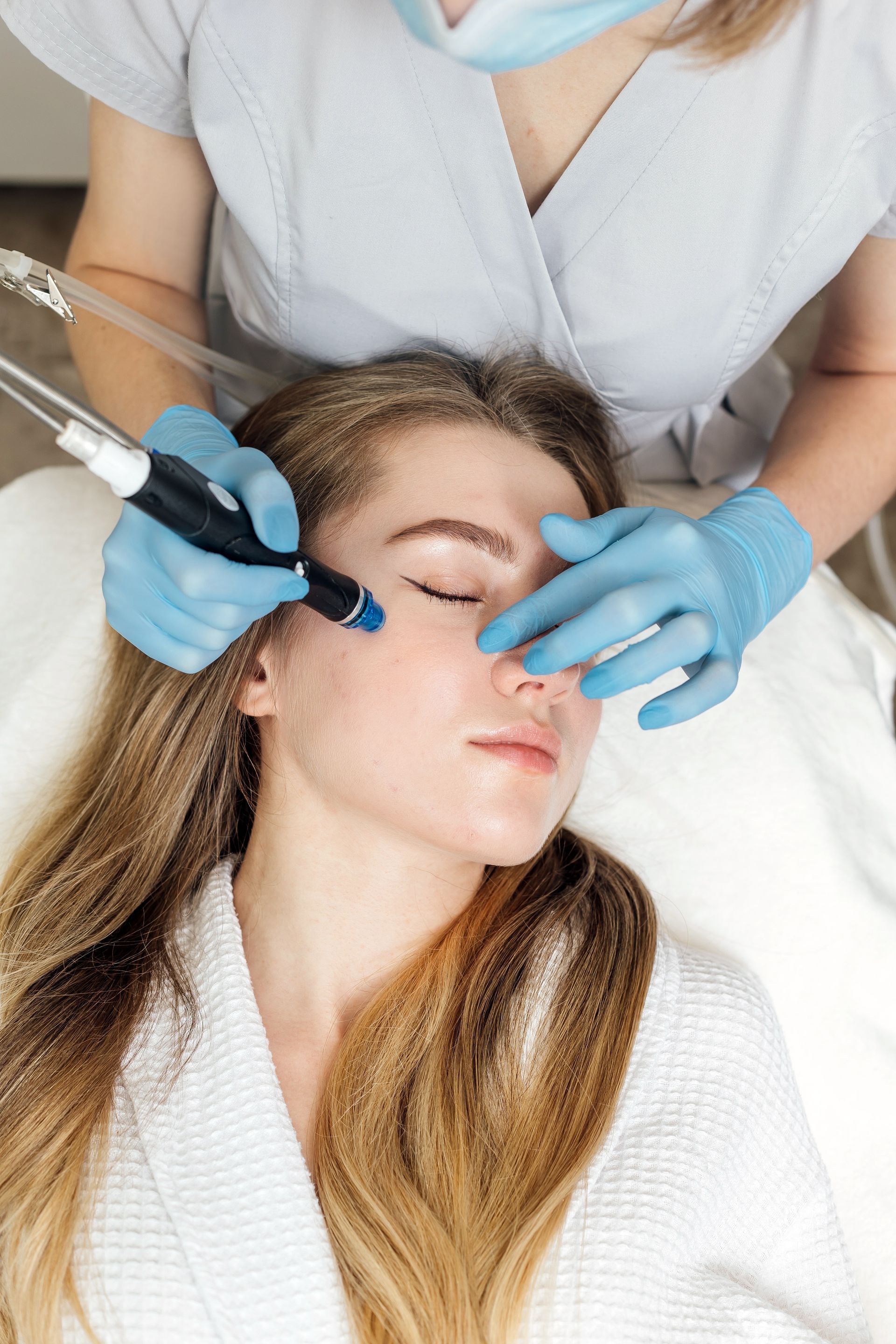 A woman is getting a facial treatment at a beauty salon.