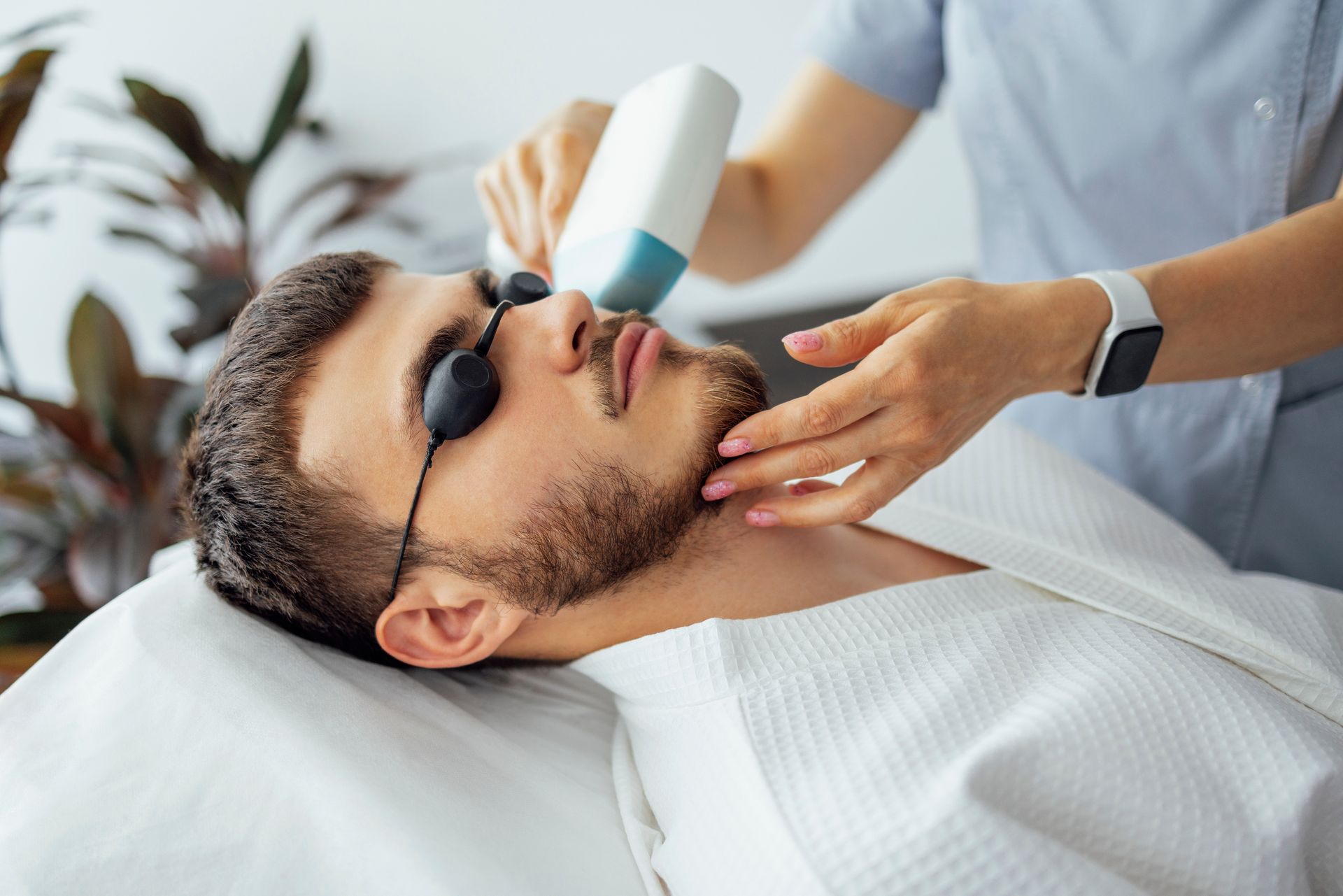 A man is getting a laser treatment on his face.