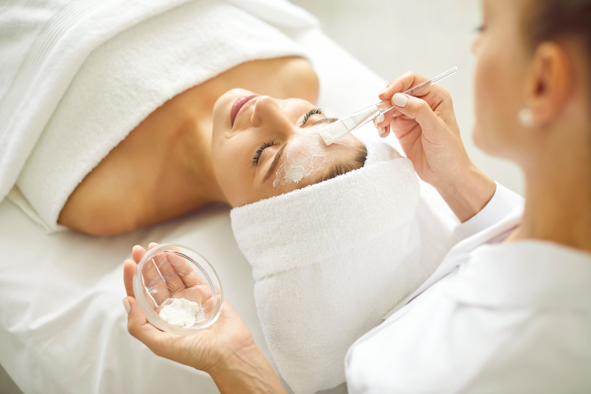 A woman is getting a facial treatment at a spa.