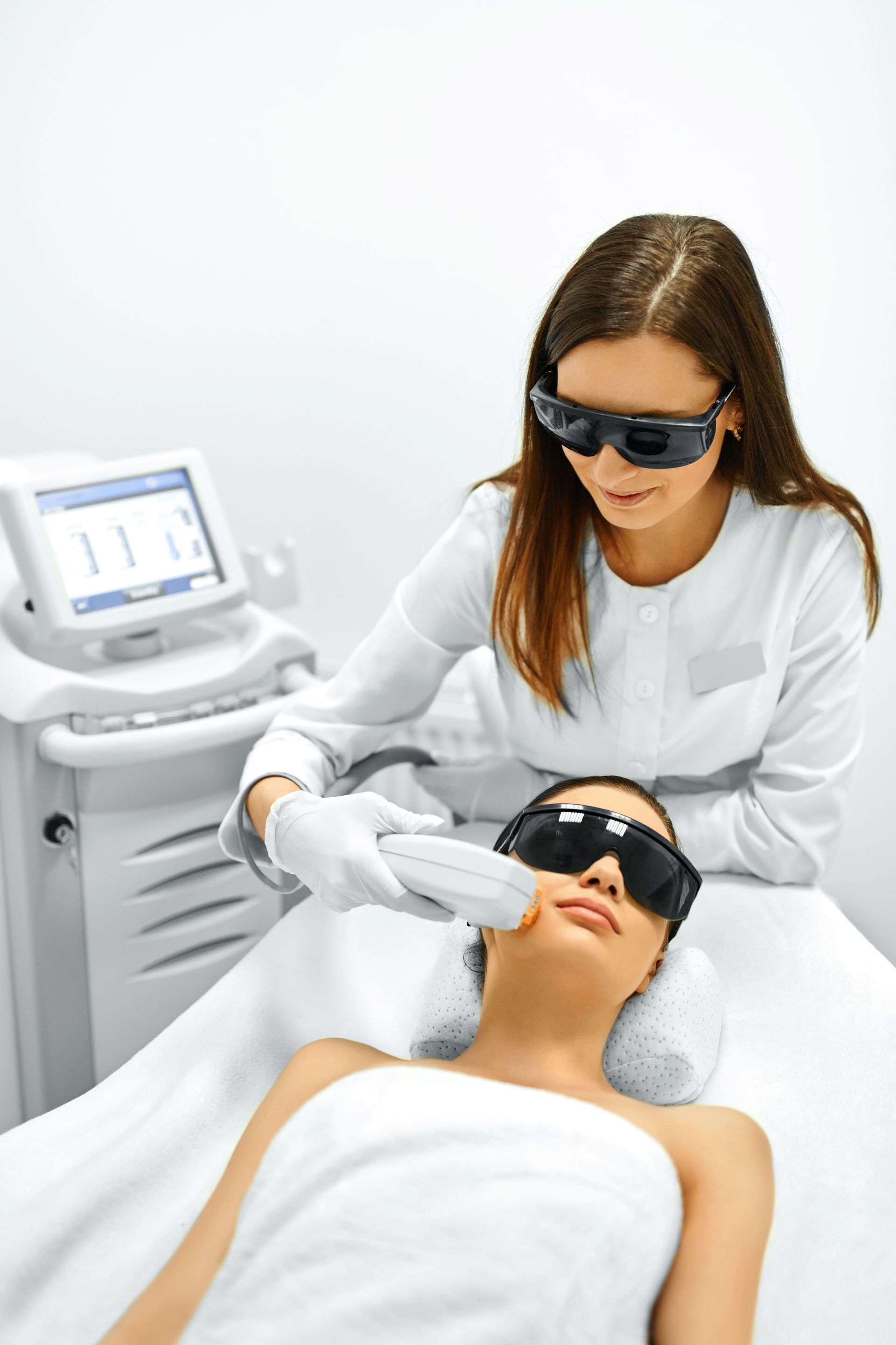 A woman is getting a laser hair removal treatment on her face.