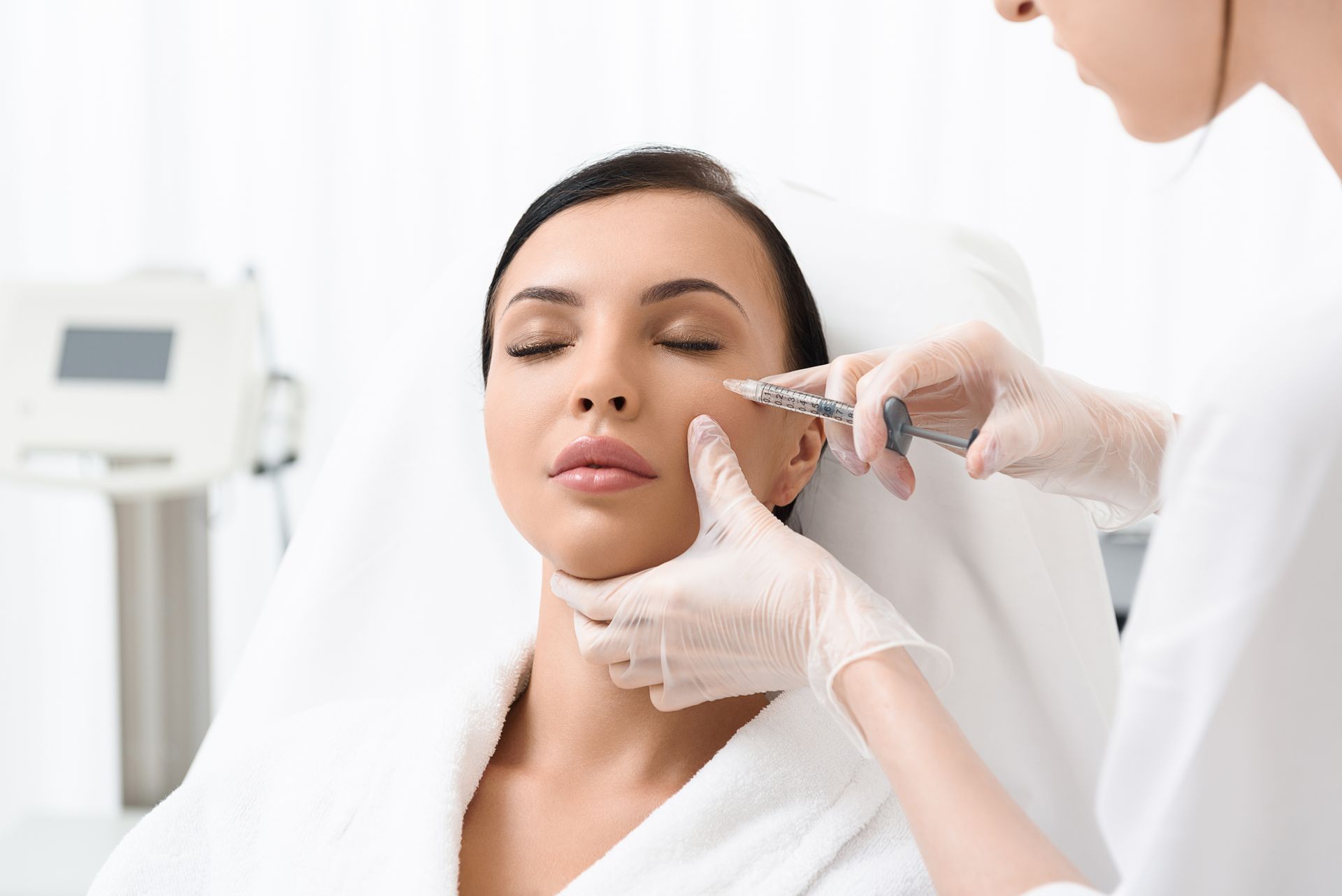 A woman is getting a botox injection in her face.