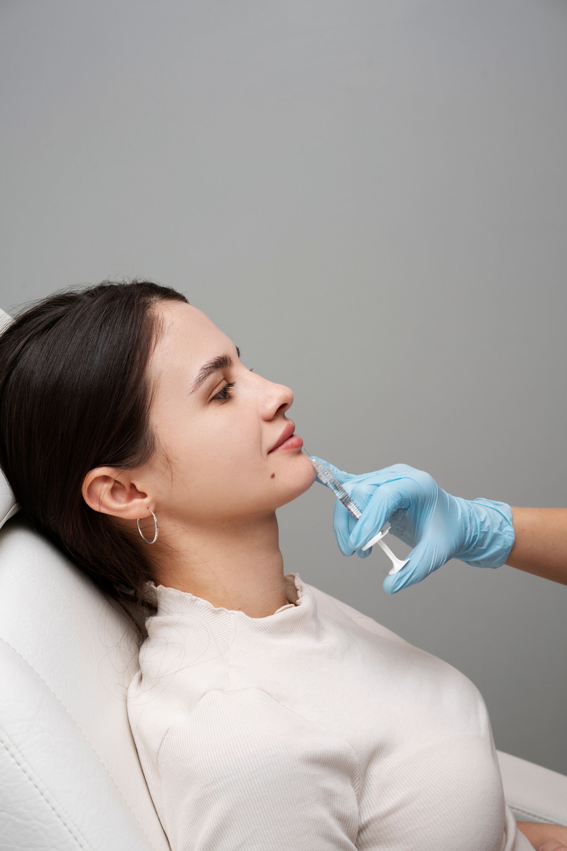 A woman is getting a botox injection in her face.