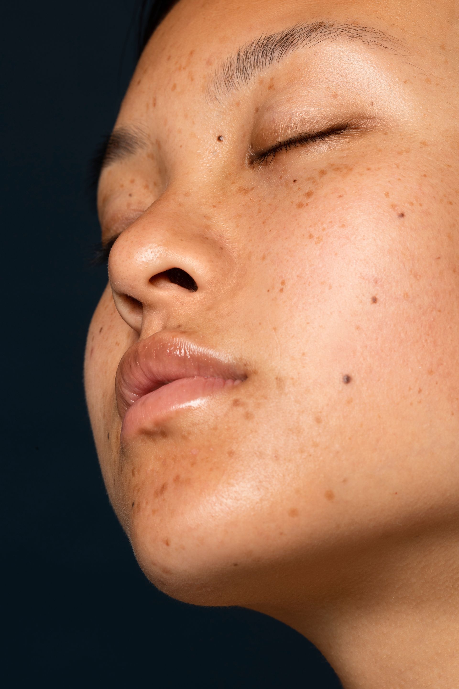 A close up of a woman 's face with her eyes closed.