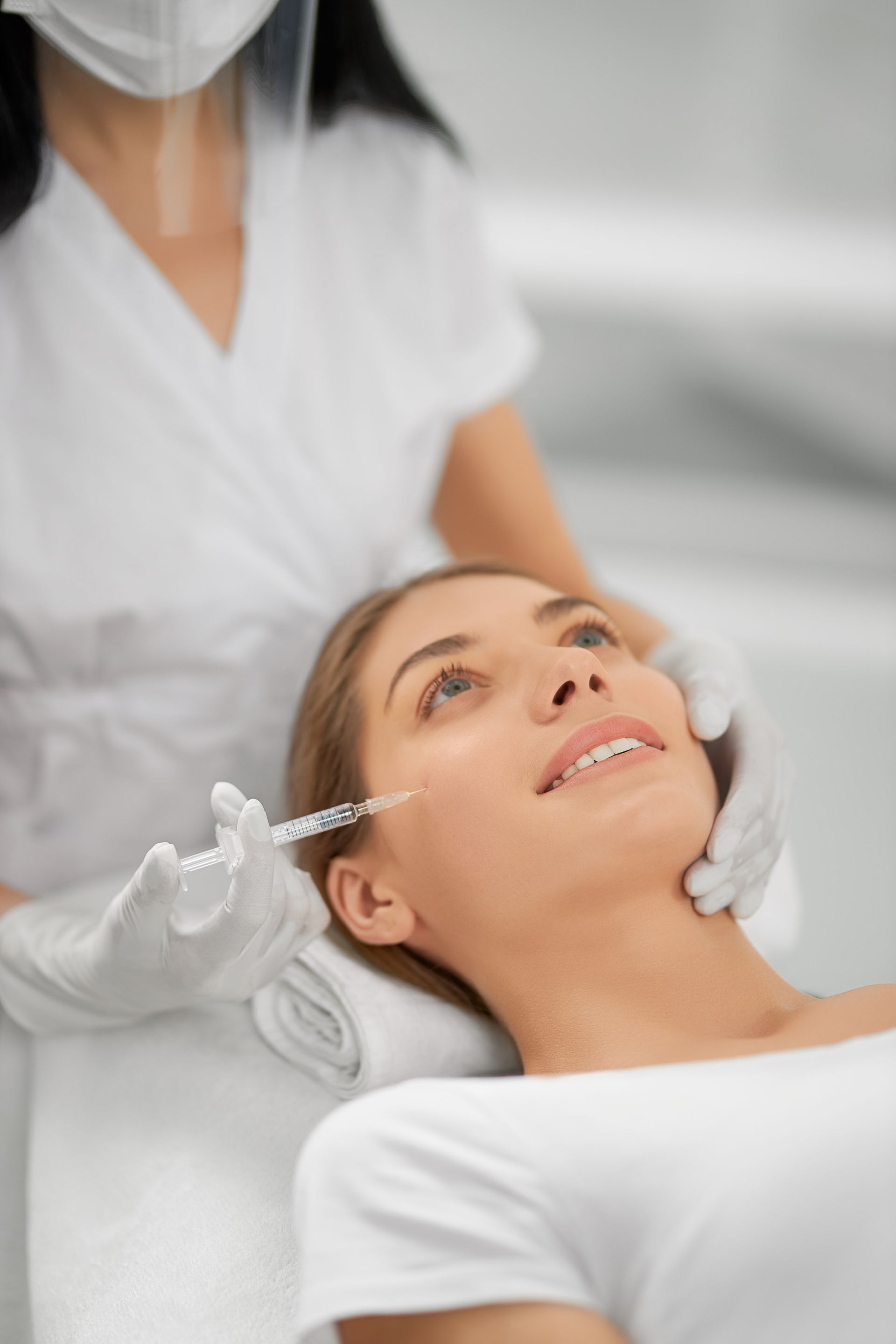 A woman is getting an injection in her face at a beauty salon.