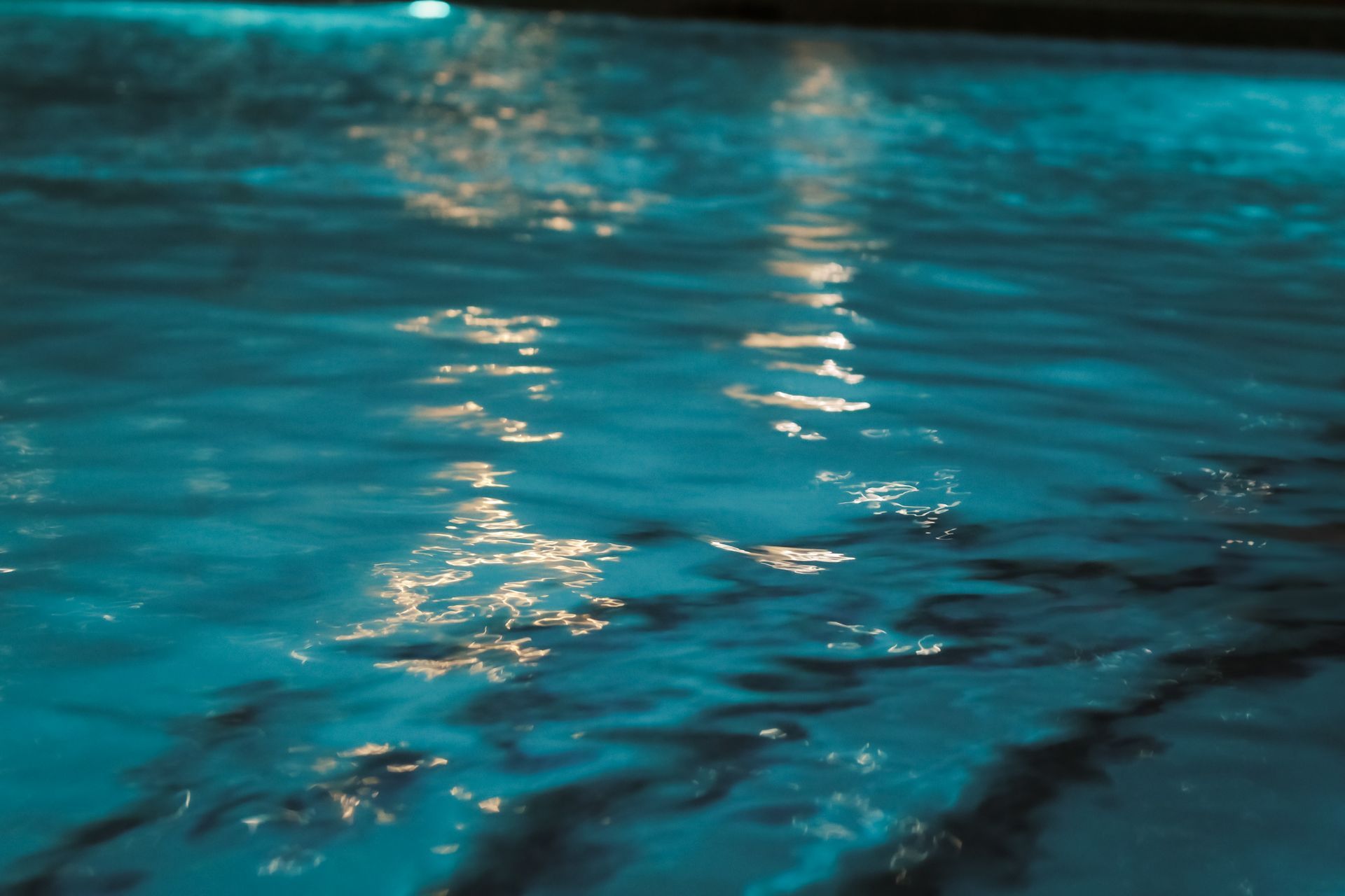 Rippled blue water with shimmering light reflections.