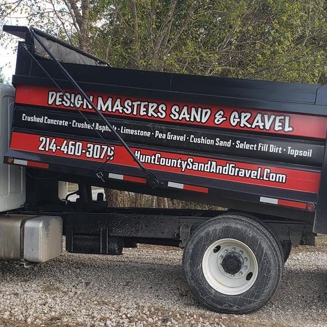 A dump truck that says design masters sand and gravel