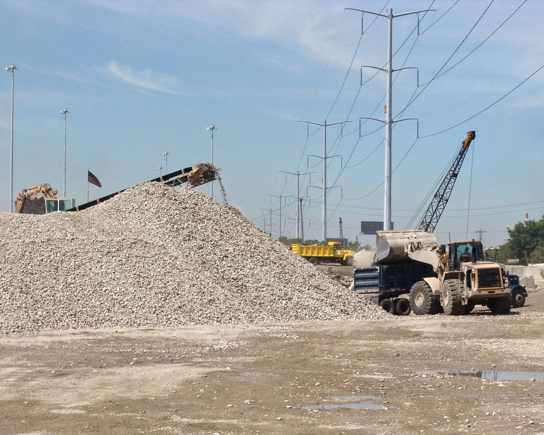 A large pile of gravel sits in the middle of a construction site