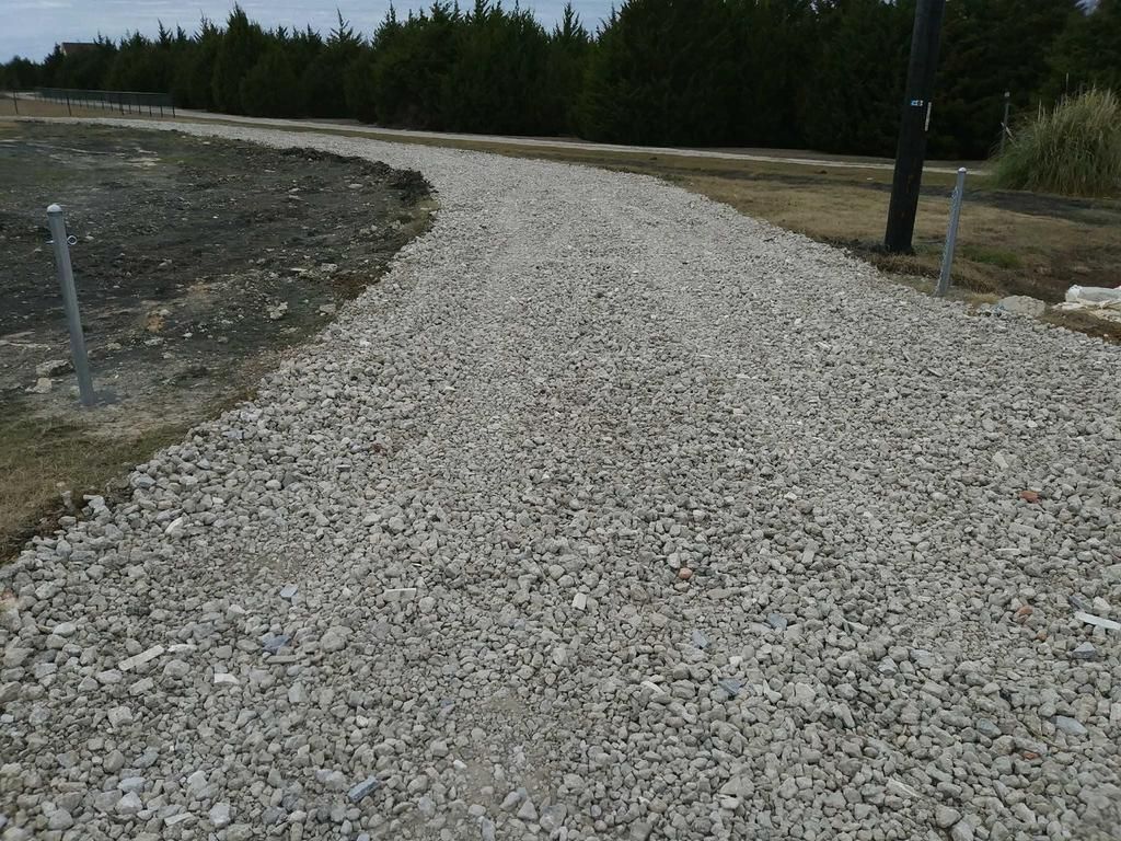 A gravel road with trees in the background