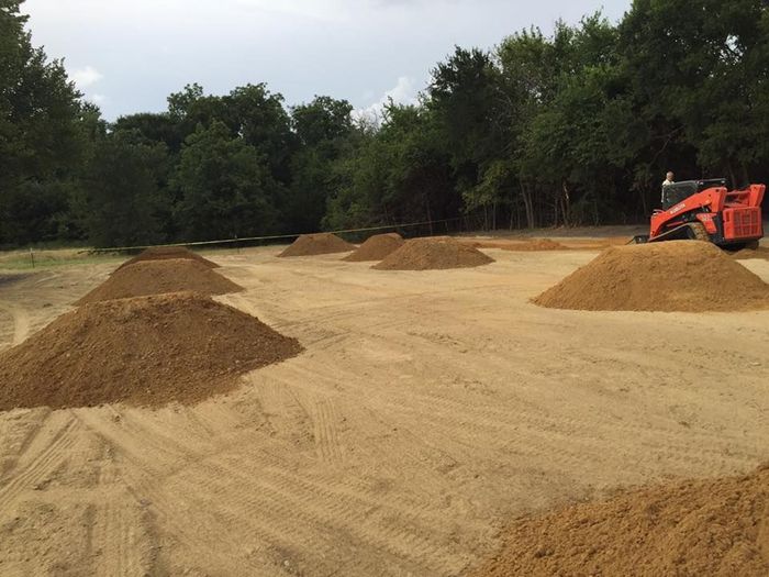 A large pile of dirt is sitting on top of a dirt field.