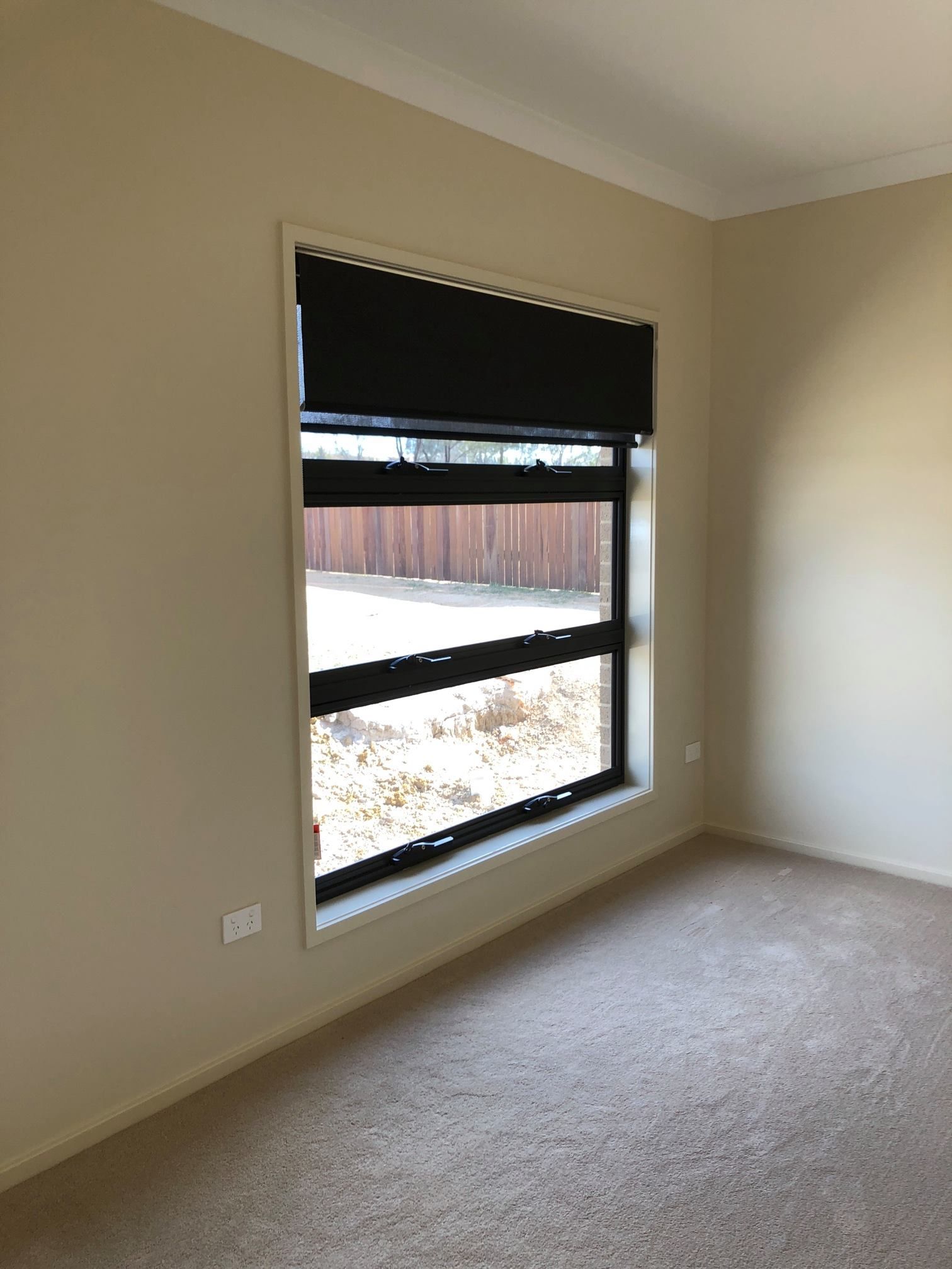 A Pair of Roller Blinds Hanging on A Window in a Bedroom — Douglass Blinds & Security Screens in Goulburn, NSW