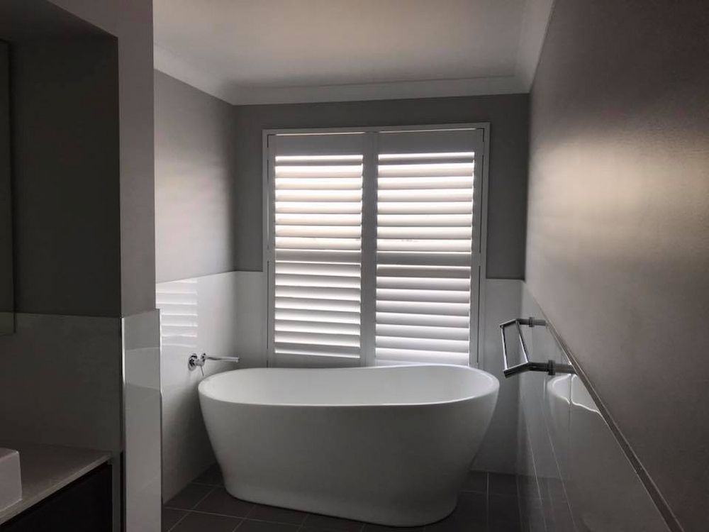 A Bathroom With Thermalite Plantation Shutters — Douglass Blinds & Security Screens in Goulburn, NSW