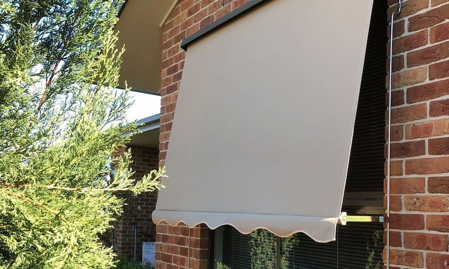 A Brick Building with A Awning on The Side of It — Douglass Blinds & Security Screens in Goulburn, NSW