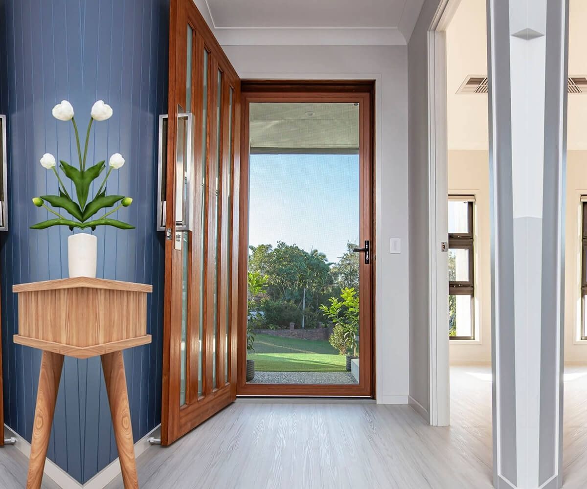Entryway with open wooden door leading to a backyard. A small wooden side table with flowers sits on the left. — Douglass Blinds & Security Screens in Southern Highlands, NSW
