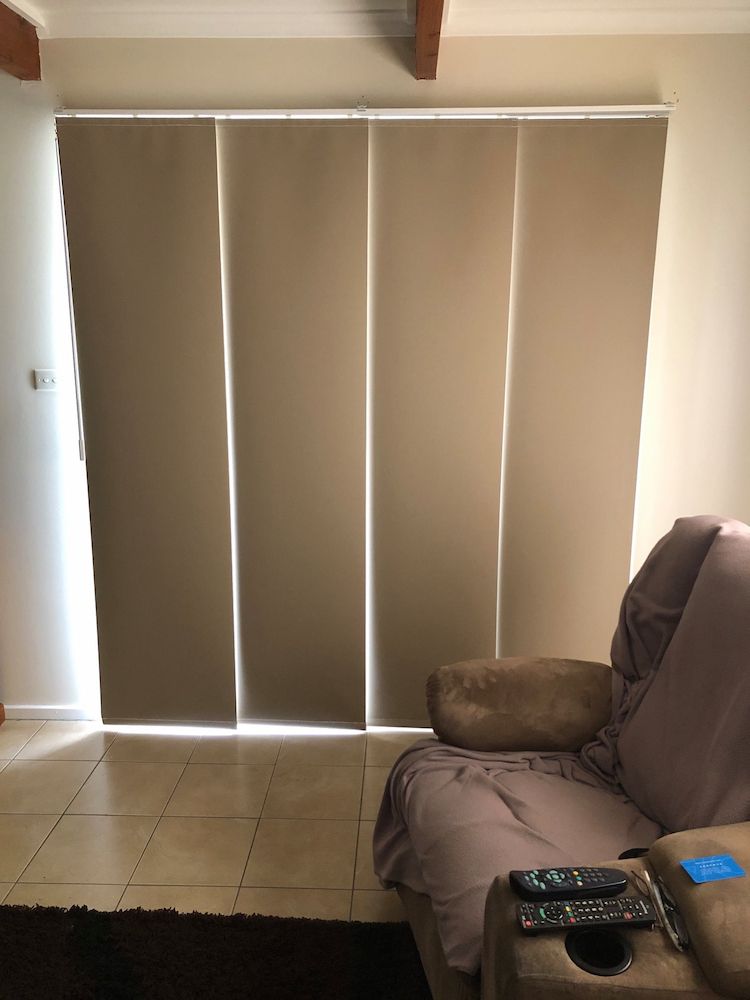 A Living Room With a Couch and a Window With Blinds — Douglass Blinds & Security Screens in Goulburn, NSW