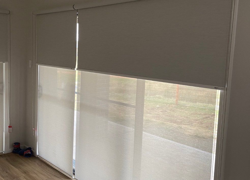 A Living Room With a Large Window and White Blinds on It — Douglass Blinds & Security Screens in Goulburn, NSW