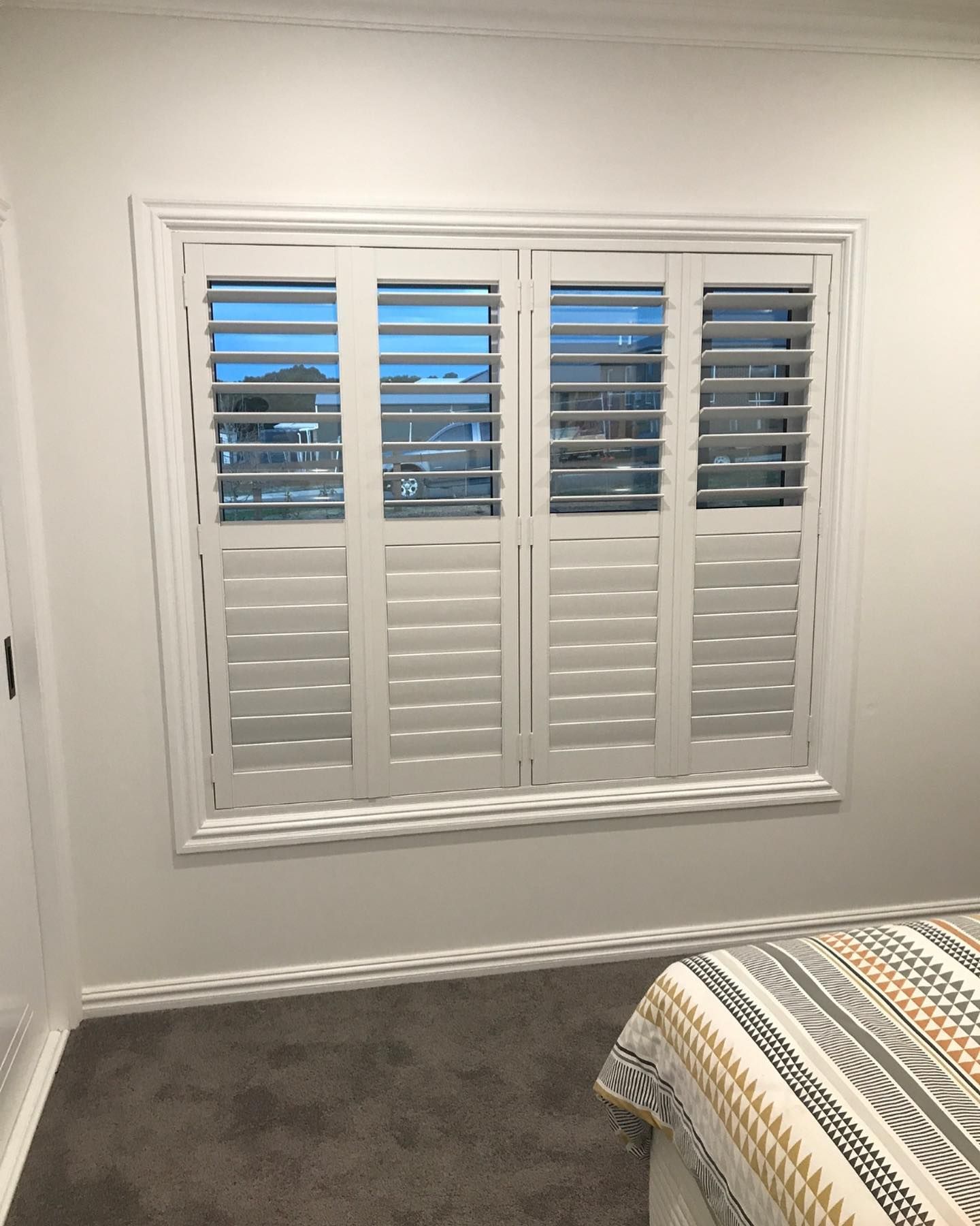 A Bedroom With Shutters on the Windows — Douglass Blinds & Security Screens in Goulburn, NSW