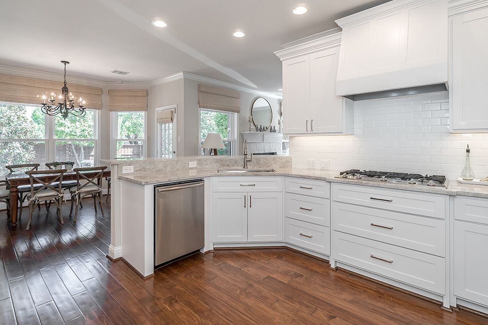 a kitchen with white cabinets and stainless steel appliances