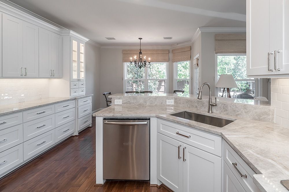 a kitchen with white cabinets and stainless steel appliances