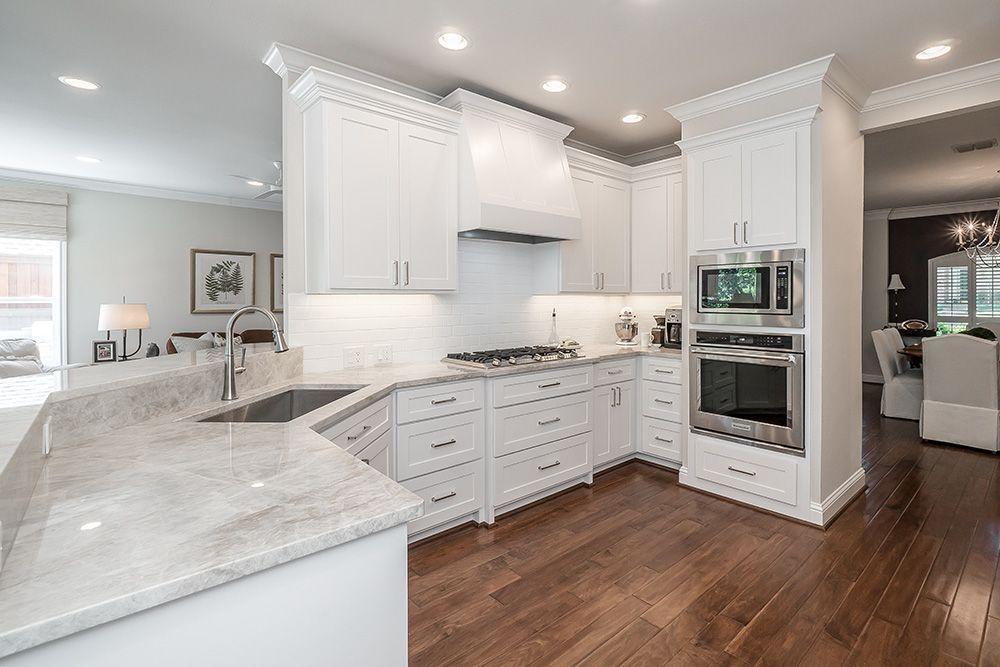 a kitchen with white cabinets and stainless steel appliances