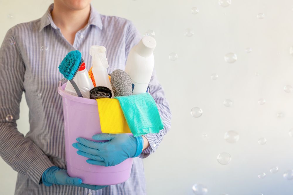 Person Holding A Bucket Of Cleaning Supplies With Cloths — RWM Cleaning in Deception Bay, QLD