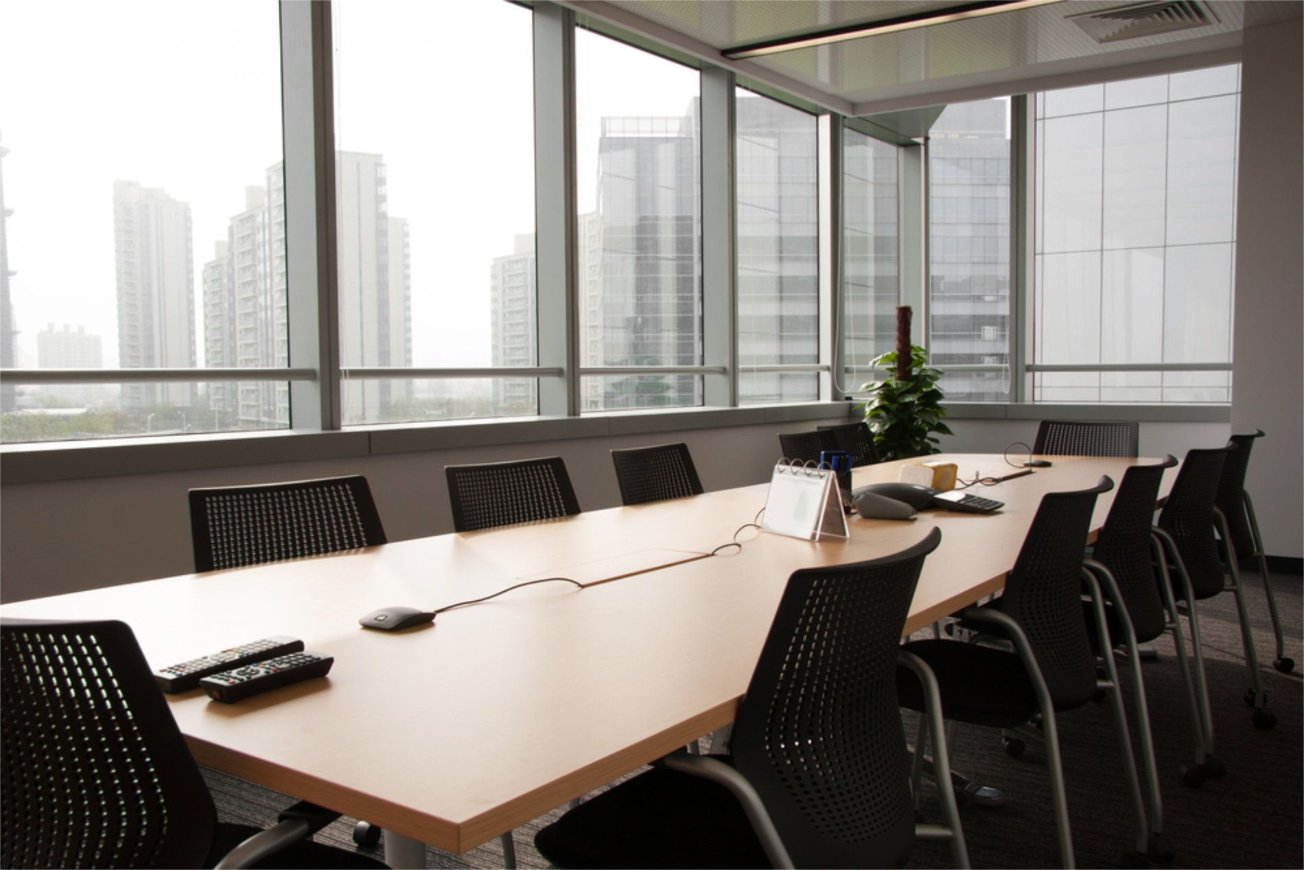 Conference room with long table, chairs, and large windows overlooking city buildings — RWM Cleaning in Deception Bay, QLD
