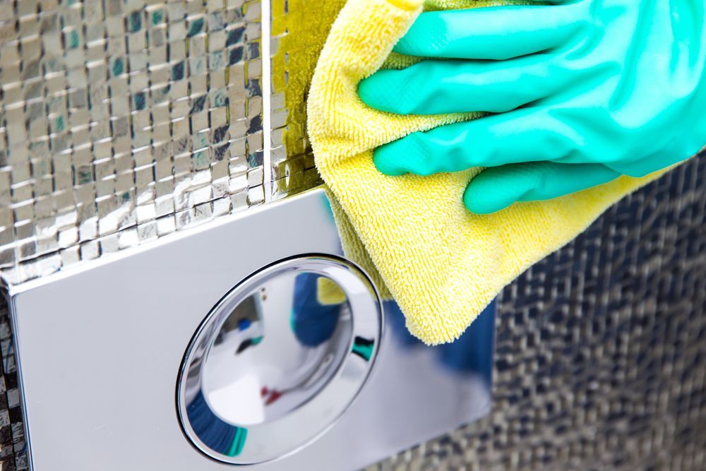 Hand in Green Glove Cleaning Chrome Toilet — RWM Cleaning in Deception Bay, QLD