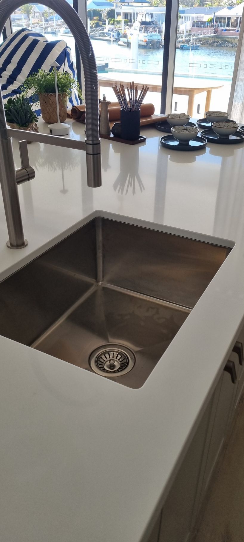 Stainless steel sink in a kitchen with a white countertop and view of a harbor — RWM Cleaning in Deception Bay, QLD