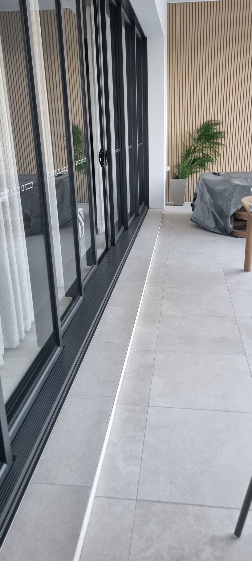 Patio with sliding glass doors, white tile, and tan curtains — RWM Cleaning in Deception Bay, QLD