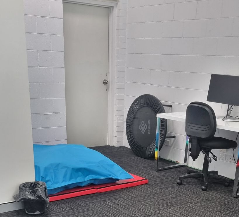 A small room with a door, bean bag, mini trampoline, desk with computer and office chair — RWM Cleaning in Deception Bay, QLD