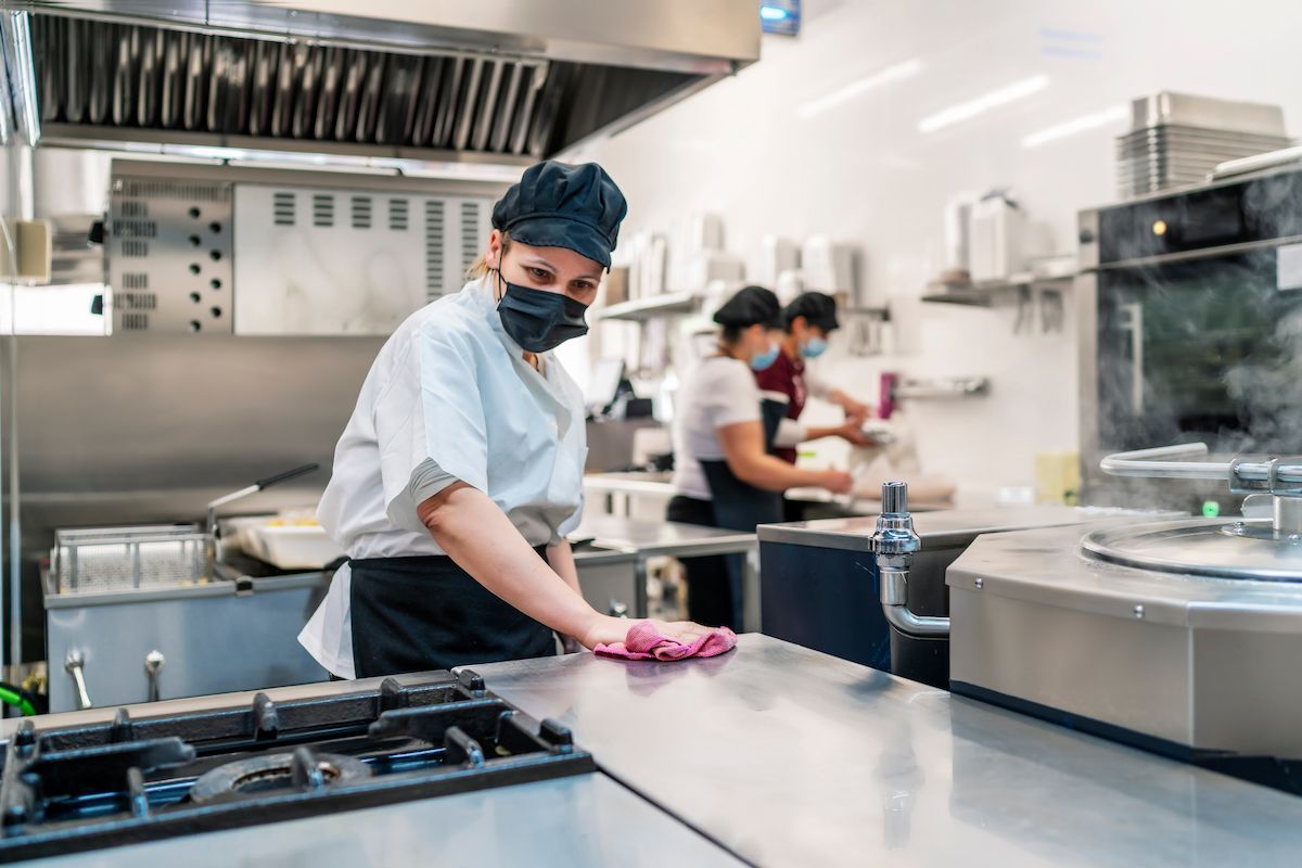 Chef Wearing a Mask Cleaning a Stainless Steel Countertop — RWM Cleaning in North Lakes, QLD