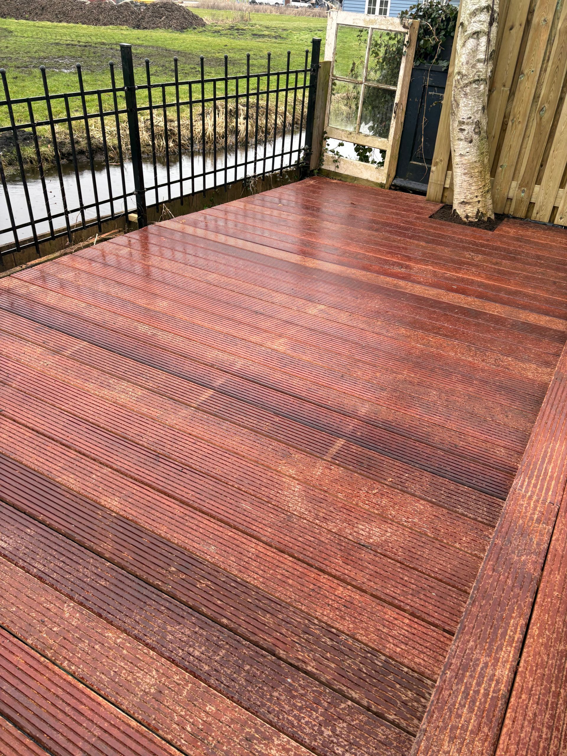 Een houten terras met een roodachtige beits 