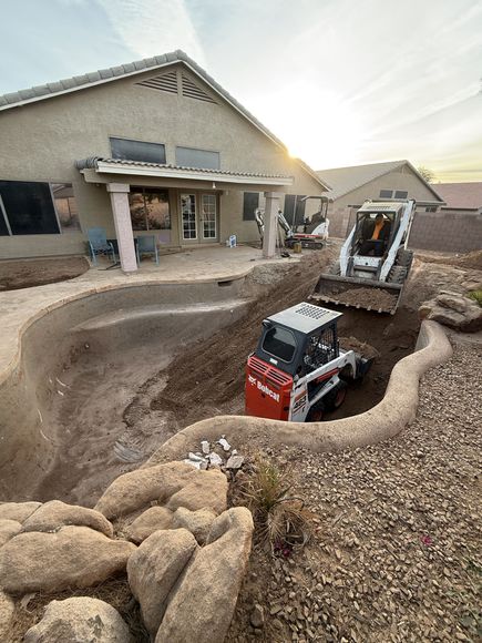 A bobcat is loading a dump truck with a bucket