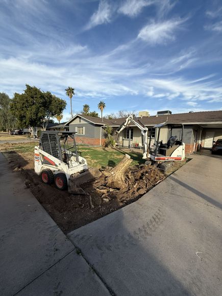 A bulldozer is driving down a dirt road in a field.
