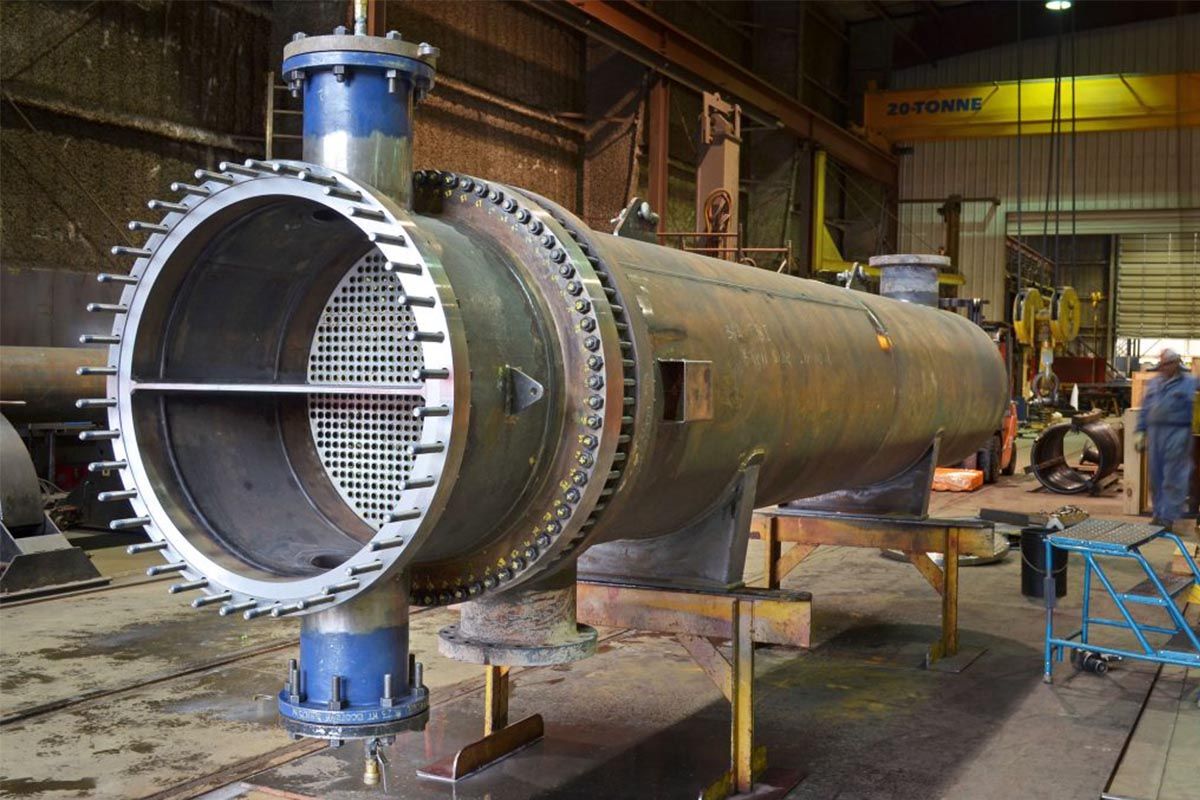 A large metal pipe is being built in a factory