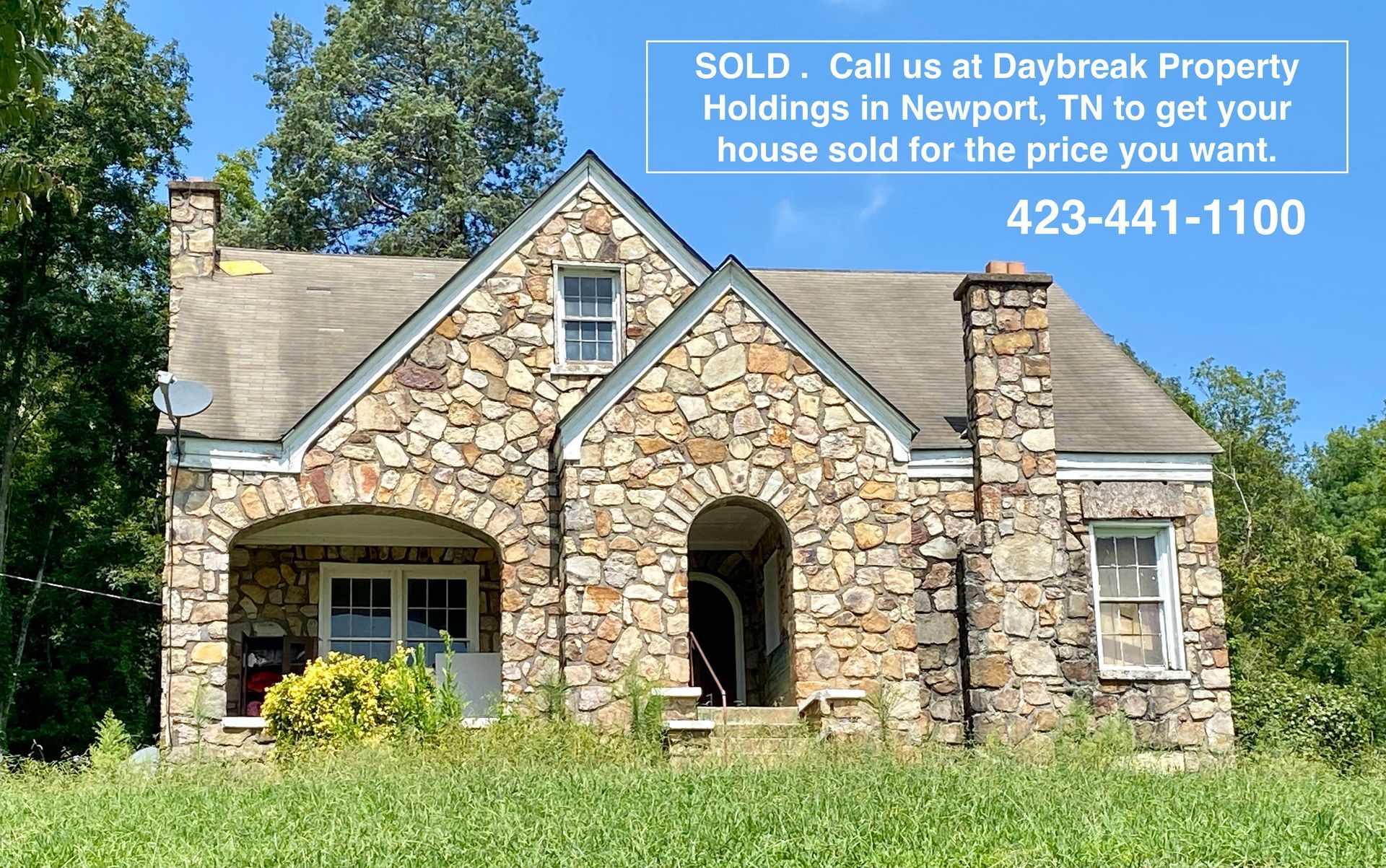 A dining room with a table and chairs and a wooden staircase.
